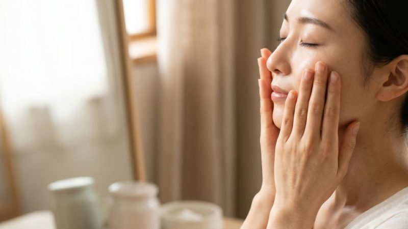 正しいスキンケア方法として、顔全体を両手で優しく包み込みしっかりと保湿ケアをする女性。
