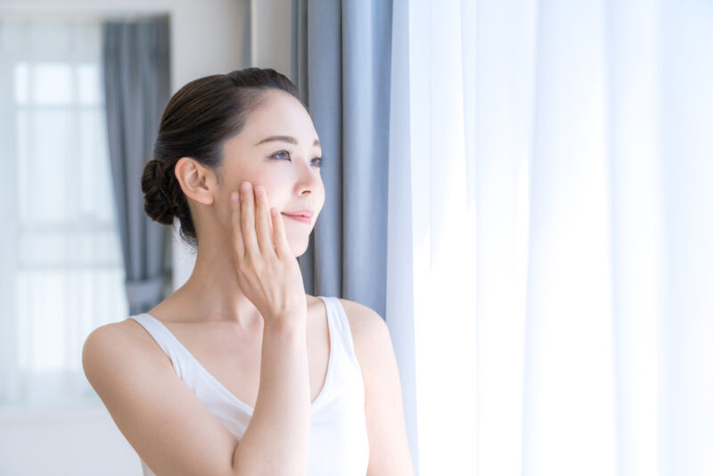セラミドサプリメントの摂取で乾燥対策を凝縮し、潤いのある素肌に満足する女性。インナーケアによるポジティブな変化のイメージ。