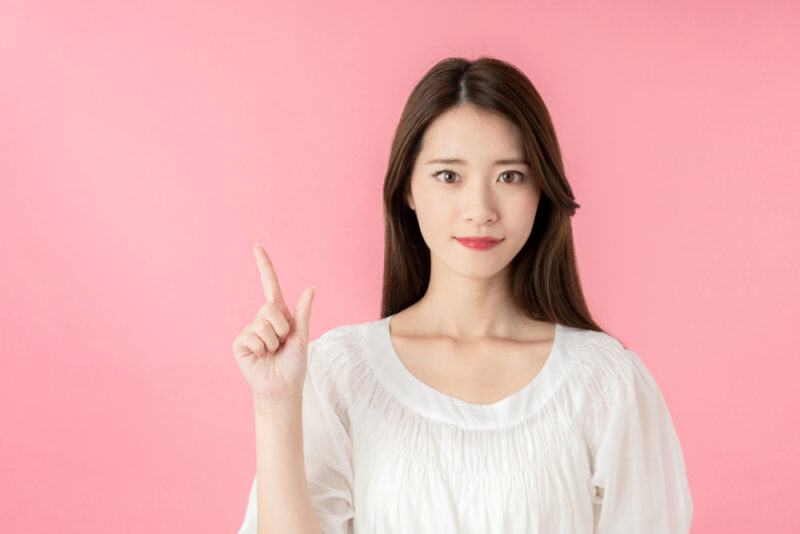 知っておきたい健康のポイントを、人差し指を立ててにこやかに説明する女性。