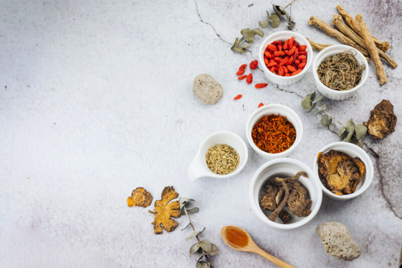 防風通聖散の主成分となる、様々な色や形の乾燥した天然生薬が小皿に盛り付けられた様子。