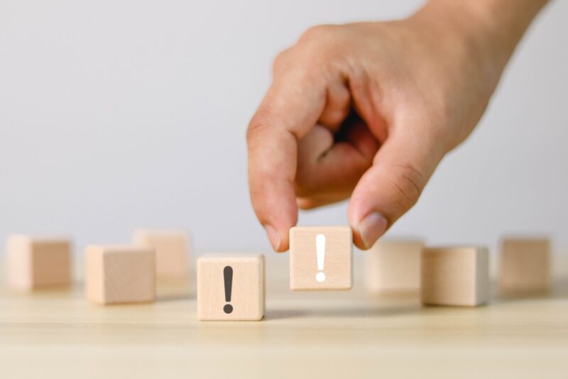 「！」マークの木製ブロックと人の手。生漢煎 防風通聖散の口コミから見えた、注目すべき点や注意点、そして活用術のヒントとなる重要な情報を提示する。