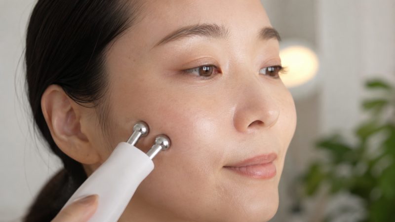 美顔器のローラー部分で頬の肉を引き上げるたるみケア。微弱電流やマッサージ効果で、気になる口角や頬のラインを効率よく刺激。