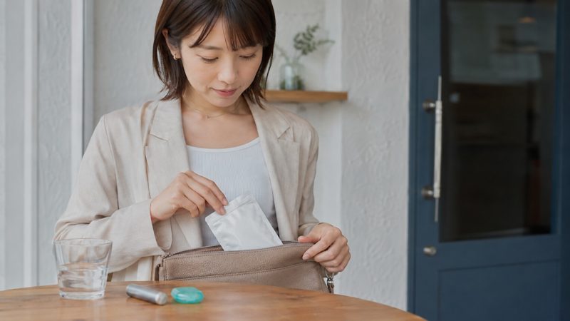 持ち運びしやすさで選ぶ口臭サプリを、外出用のバッグに入れて準備する女性。