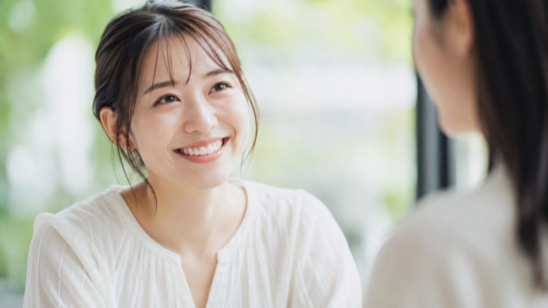 マウスピース矯正のおすすめブランドを選び、理想の歯並びを実現して笑顔で談笑する女性の様子。