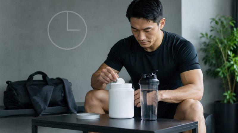 摂取タイミングを意識しながら、プロテインやHMBの粉末をシェイカーで準備するトレーニング中の男性。