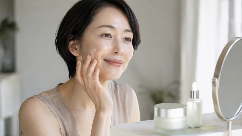 鏡を見ながら丁寧に毛穴ケアを行う女性。肌の変化を楽しみながら、自分に合った化粧水を選ぶ大切さを表現。