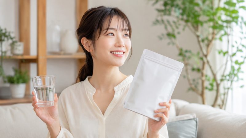 コラーゲンサプリ選びに迷った時のイメージ。白いパッケージのサプリメントを手に、健康的な生活習慣を意識する女性。
