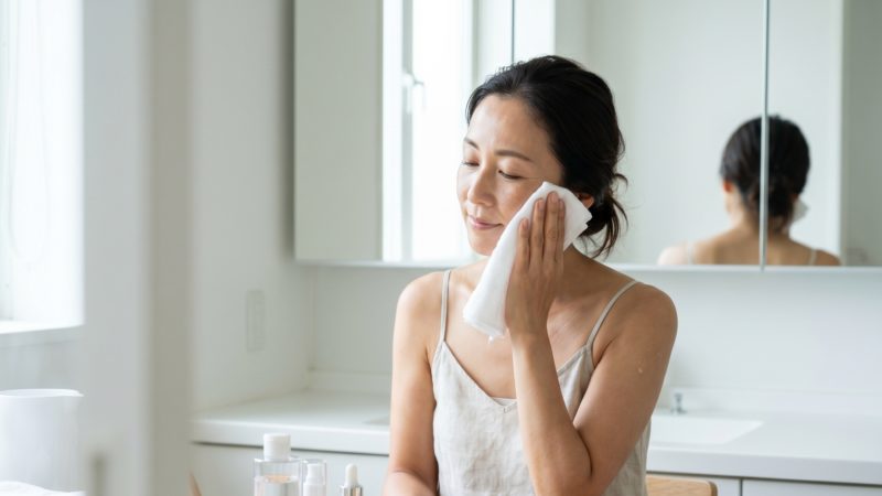 洗顔後にタオルで顔を拭く女性。美白ケアサプリを取り入れる前段階の、清潔な肌環境作り。