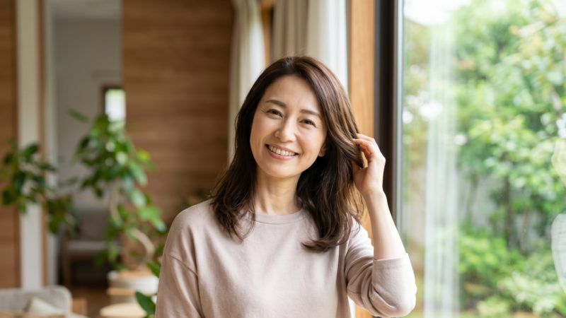 女性用育毛剤でおすすめのヘアケアを継続し、髪のボリュームとツヤに自信を取り戻した女性。