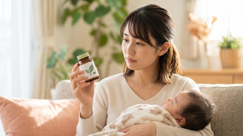 産後・授乳期の健康維持に葉酸サプリを活用。育児の合間に、自分と赤ちゃんの健康のために栄養成分を確認するシーン。