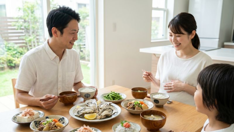 妊活・妊娠期に大切な栄養バランスの良い和食を囲む家族。葉酸が豊富な牡蠣や緑黄色野菜が並ぶ食卓。