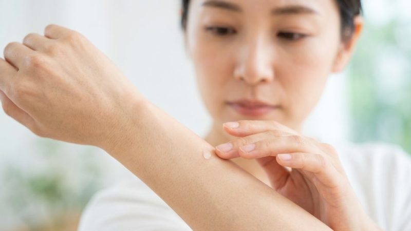 敏感肌向けのスキンケア選びで、購入前に腕にジェルを乗せてパッチテストを行う女性。
